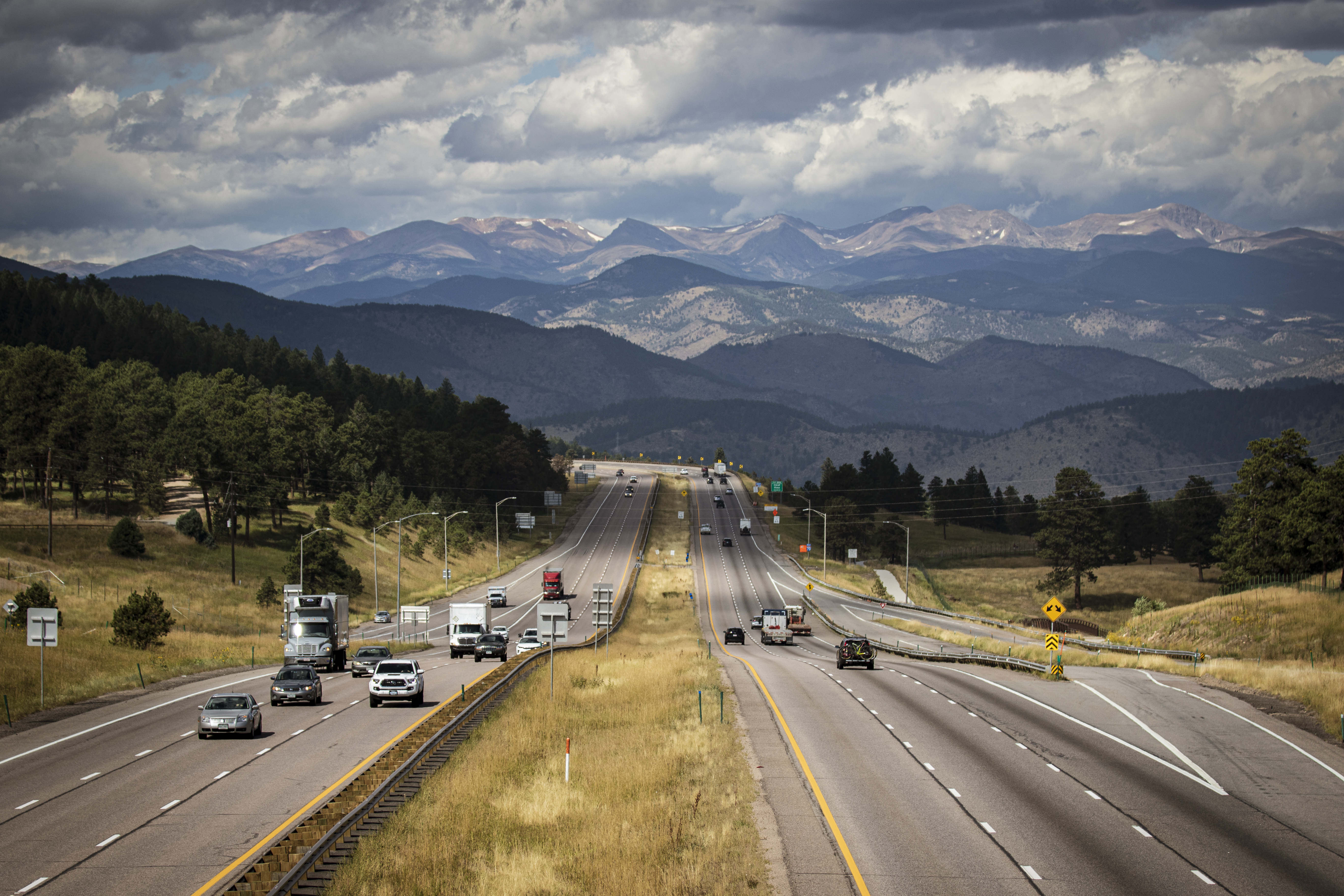 Scenic view of the Rocky Mountains in Colorado, looking west along Interstate 70 with cars traveling.