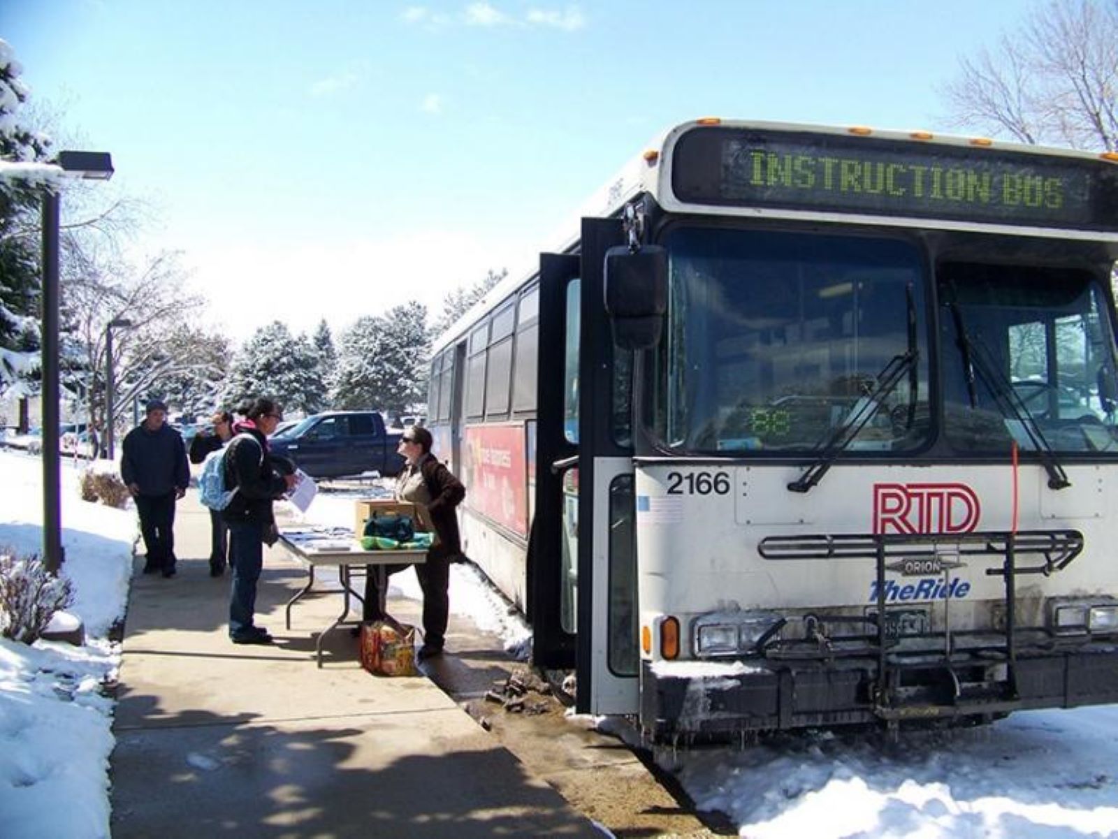 A Regional Transportation Bus picking up a group of commuters in Boulder county.