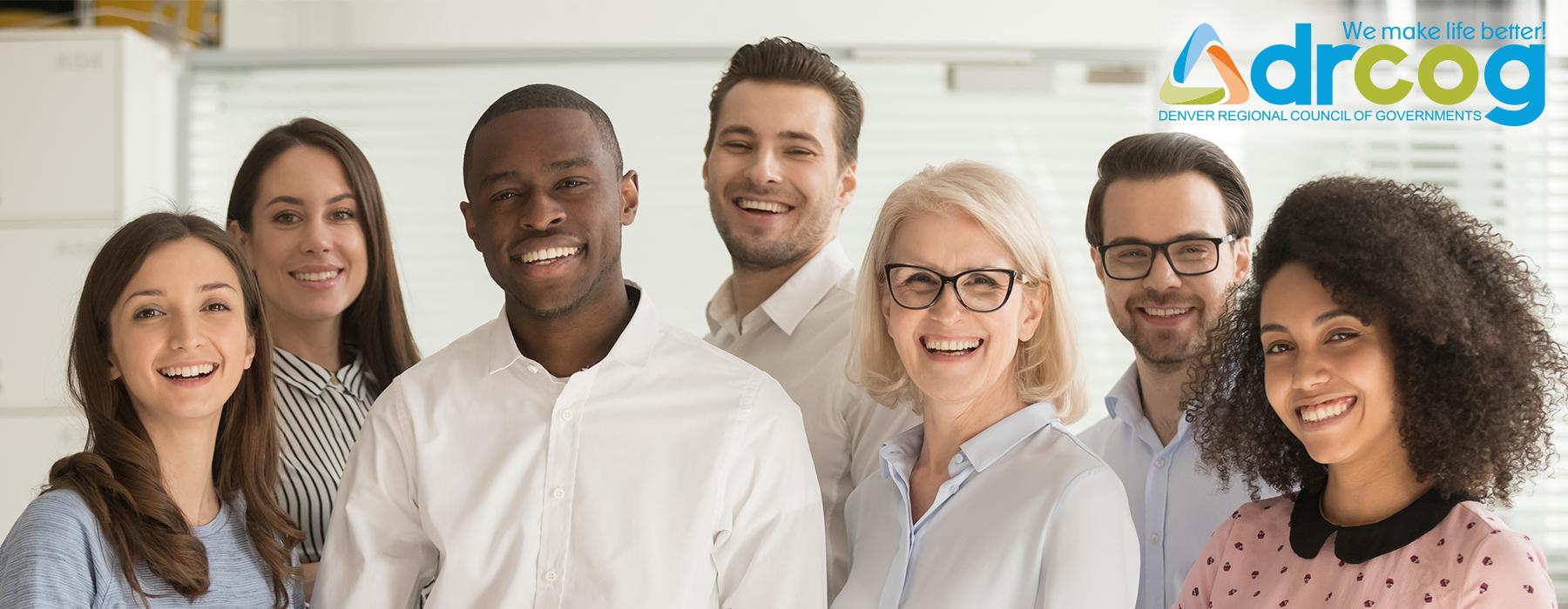 A racially and gender diverse group of smiling coworkers.
