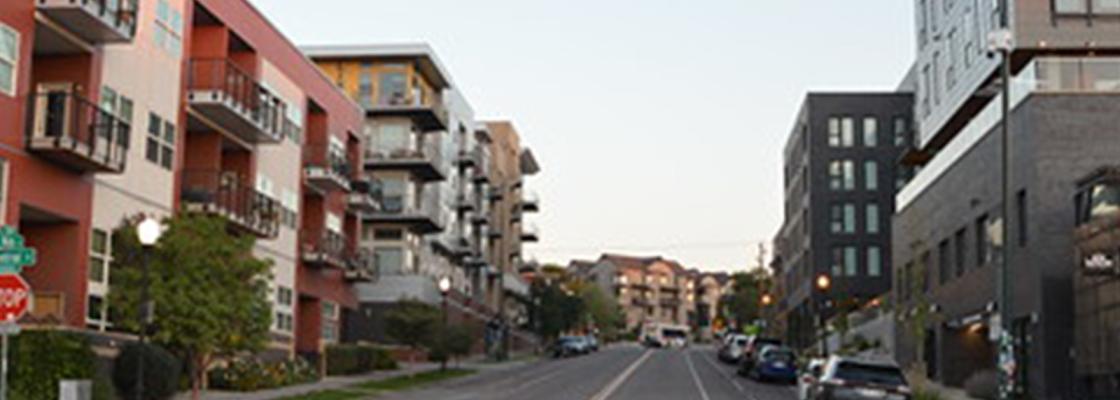 An urban setting in Colorado with residential and commercial buildings lining a street.