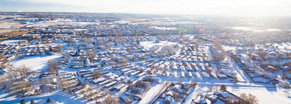 The City and County of Broomfield, from above, on a sunny, winter day. Snow covers a residential neighborhood.