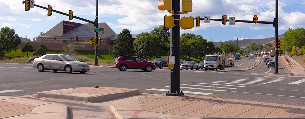 Busy intersection in the city of Golden, CO. A red Ford Edge SUV is turning left. 