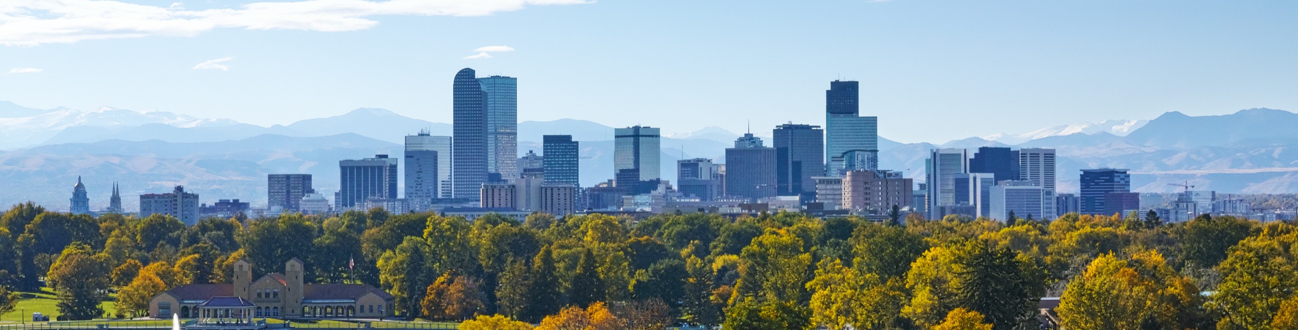 Image of downtown Denver in the fall with mountains in the background.